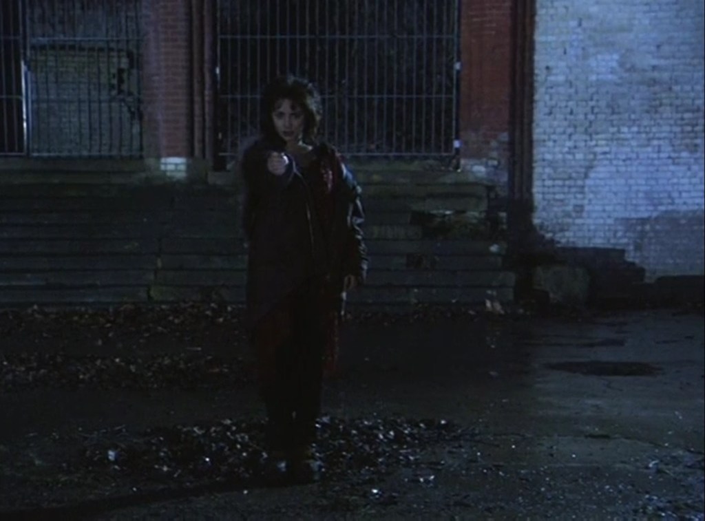 Laura Fraser, as the Lady Door points an object at the viewer.