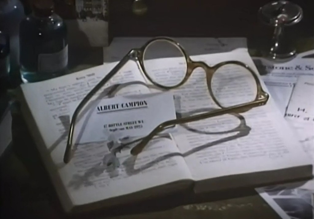 From the opening credits of the series "Campion" a set of horn-rimmed glasses are shown on top of a card that reads "Albert Campion".